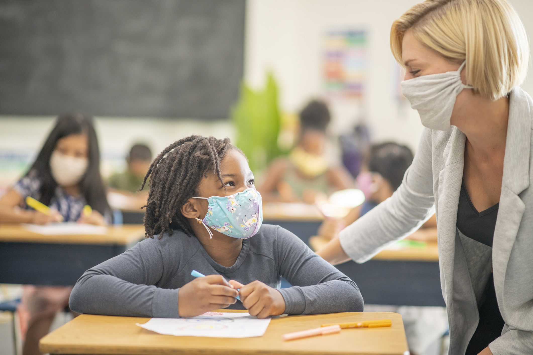 6 year old, African American student wearing a protective face mask in class