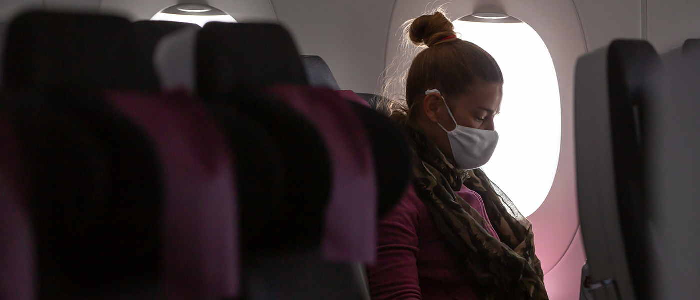 Woman on Plane wearing a mask