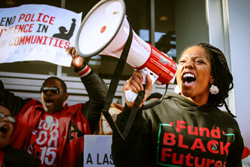 Photo from Unapologetic showing a young woman protesting while speaking into a bullhorn