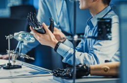 Close up photo of two researchers testing a Prosthetic hand in a lab