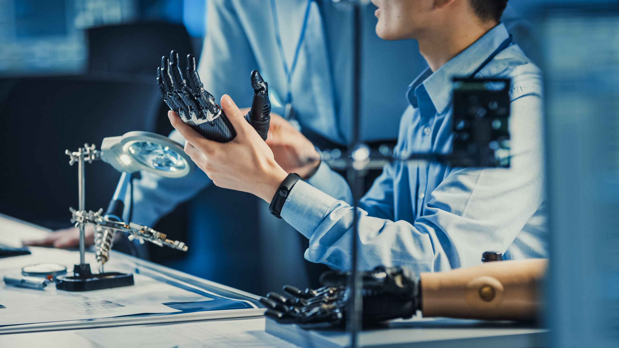 Close up photo of two researchers testing a Prosthetic hand in a lab