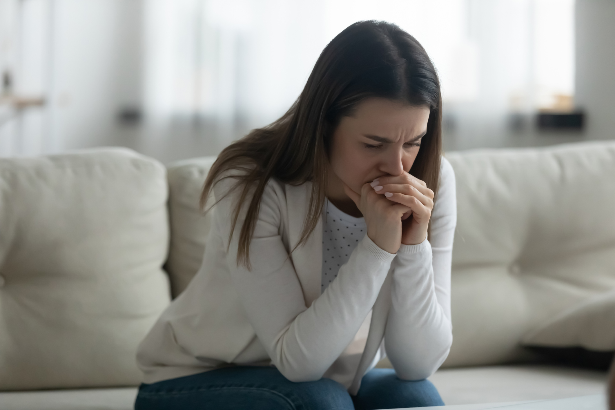 Woman goes through divorce sitting on couch crying feels depressed