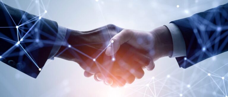Photo showing two people shaking hands with connected points laying over top to represent digital concepts