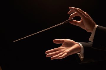 Concert conductor hands with baton