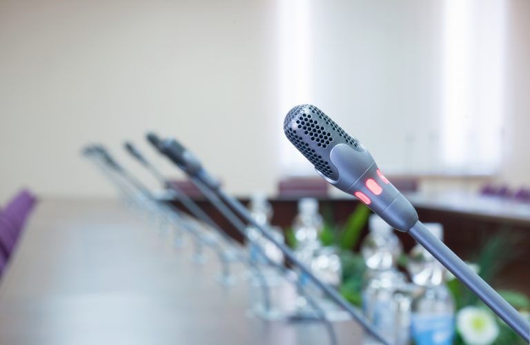 close up of a line of microphones in empty conference hall
