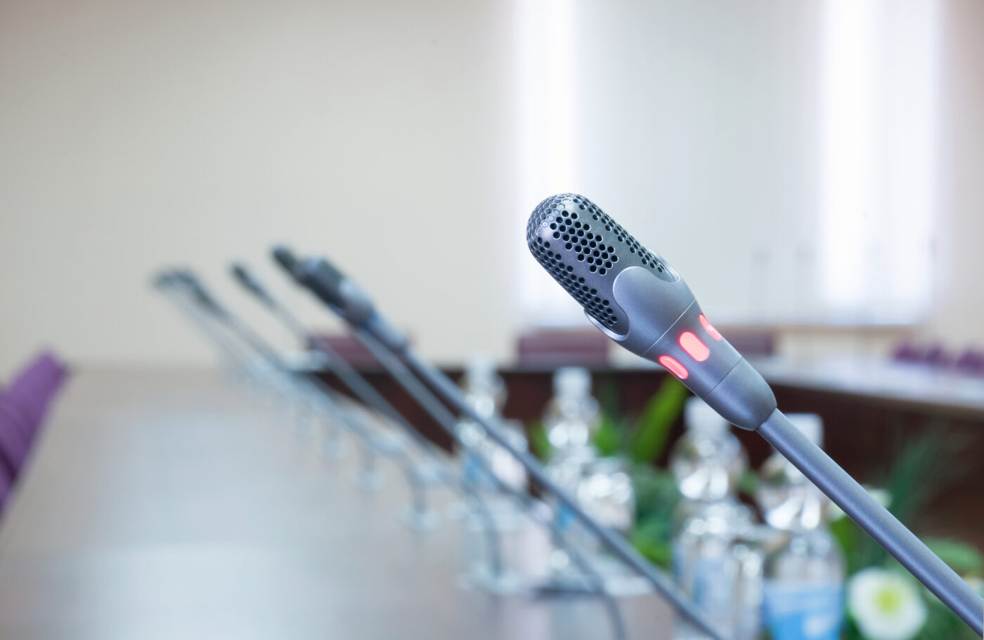 close up of a line of microphones in empty conference hall