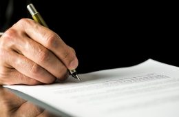 Male hand signing a contract, employment papers, legal document