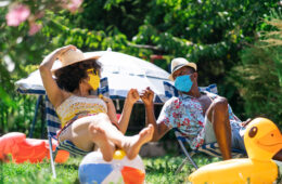 Afro Couple wearing protective face mask having staycation fun on back yard and practicing alternative greeting, during COVID-19