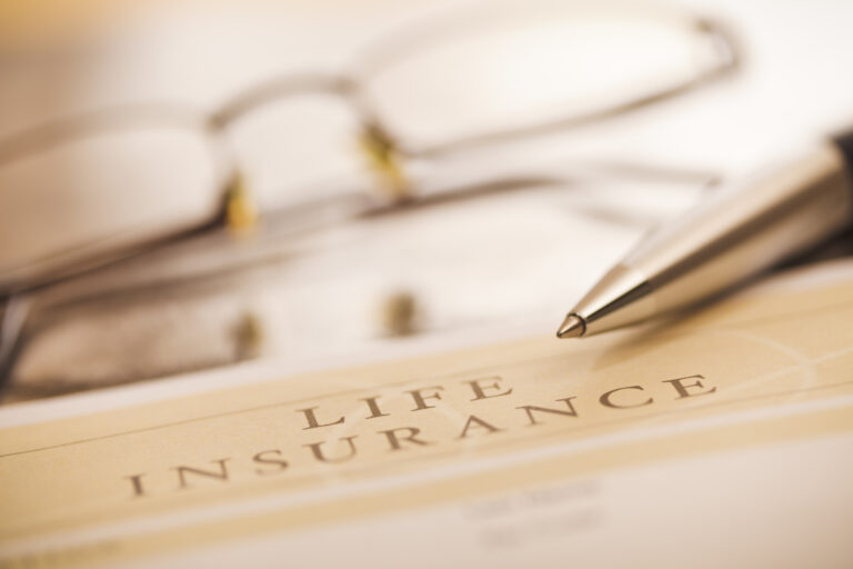 Document entitled life insurance, a pen and glasses on a desk