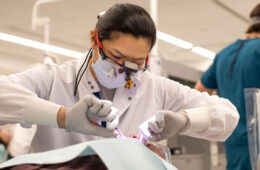Photo of a CWRU dental student working on a patient's teeth