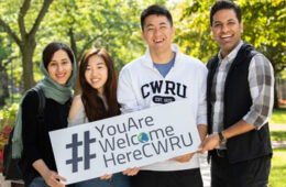 Photo of four CWRU students holding a sign that says "You Are Welcome Here CWRU"
