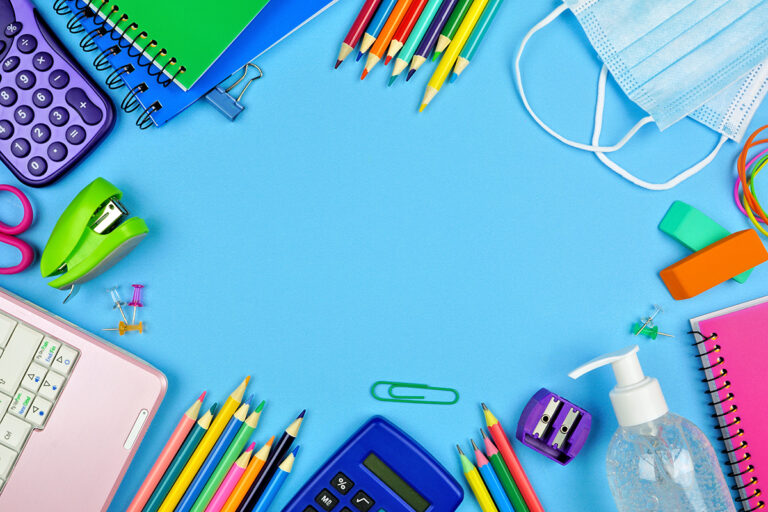 School supplies and COVID 19 prevention frame on a blue paper background