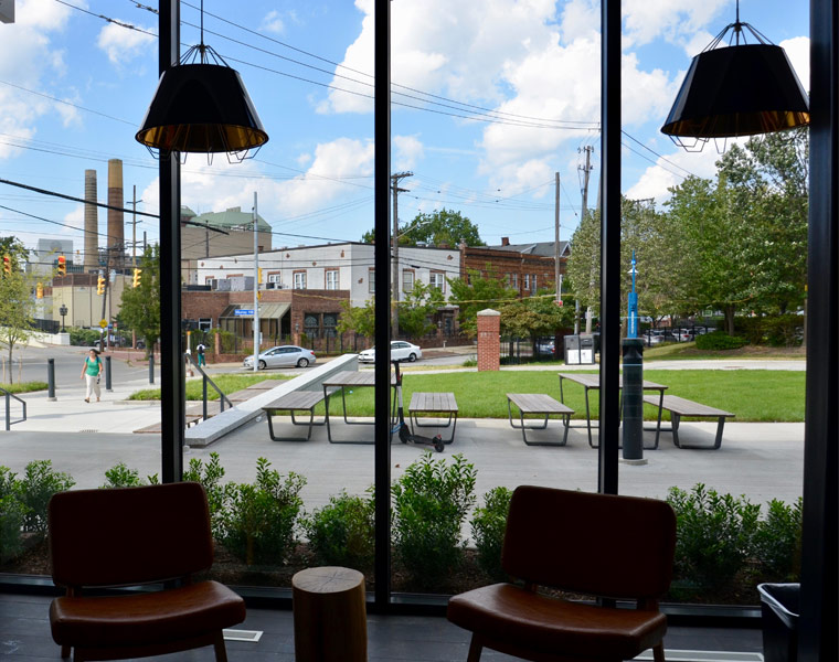 Photo looking out from the large windows of Fribley Commons showing the view of campus and an outdoor seating area
