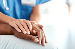 doctors hands on a patient's hands