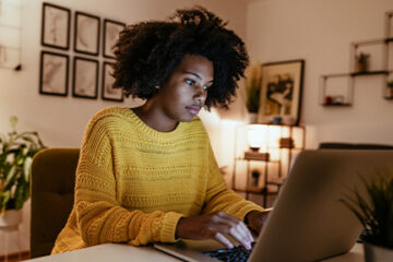 Young African American businesswoman at home office, working late