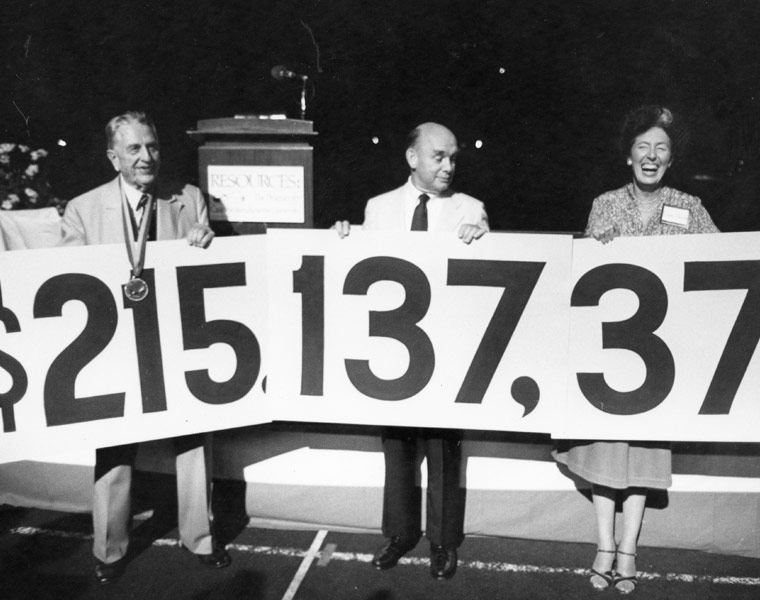Curtis L. Smith, former CWRU President Louis A. Toepfer and Elaine “Lainie” Hadden hold a sign to celebrate $2.15 million raised