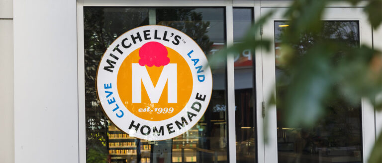 Photo of the Mitchell's Ice Cream sign in the window of its Uptown location