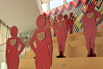 Photo of the figures with plaques for the Silent Witness Project in Tinkham Veale University Center on the grand staircase
