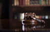 Photo of a gavel on a desk with a blurred bookcase in the background