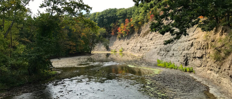 Photo of the a river winding through the Rocky River Reservation alongside a rocky dropoff