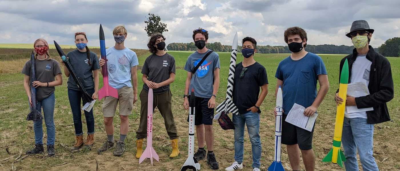 Photo of members of the Case Rocket Team posing for a photo outside with their rockets