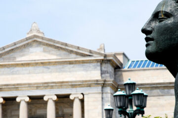 Photo of the top of a statue in front of the Cleveland Museum of Art with the museum's front in the background