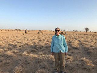 Photo of Deborah Lindell in a grassy area of Kenya