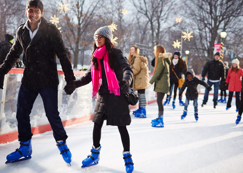 Photo of a couple ice skating at Wade Oval with others in the background