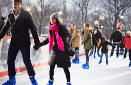 Photo of a couple ice skating at Wade Oval with others in the background