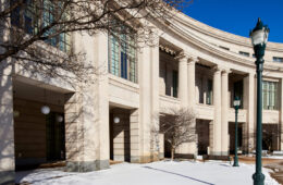 Photo of the exterior of Kelvin Smith Library with snow on the ground in front of it and blue skies overhead