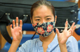 Photo of a student wearing a mask and talking in class
