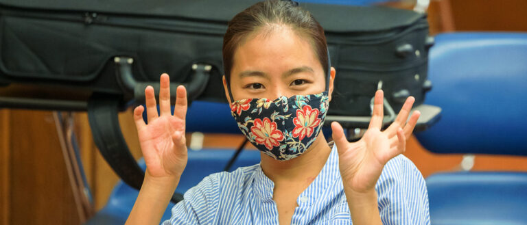 Photo of a student wearing a mask and talking in class