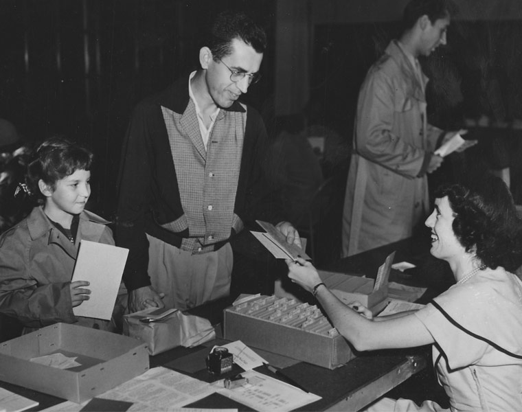 Black and white photo of students at a table registering for classes in 1951