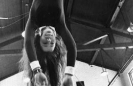 Black and white photo of a student hanging on a flying trapeze during an Intersession course in 1973