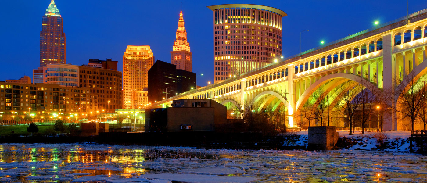 Photo of the Cleveland skyline at night with ice and snow on the river in the foreground