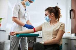 Photo of a masked individual giving blood