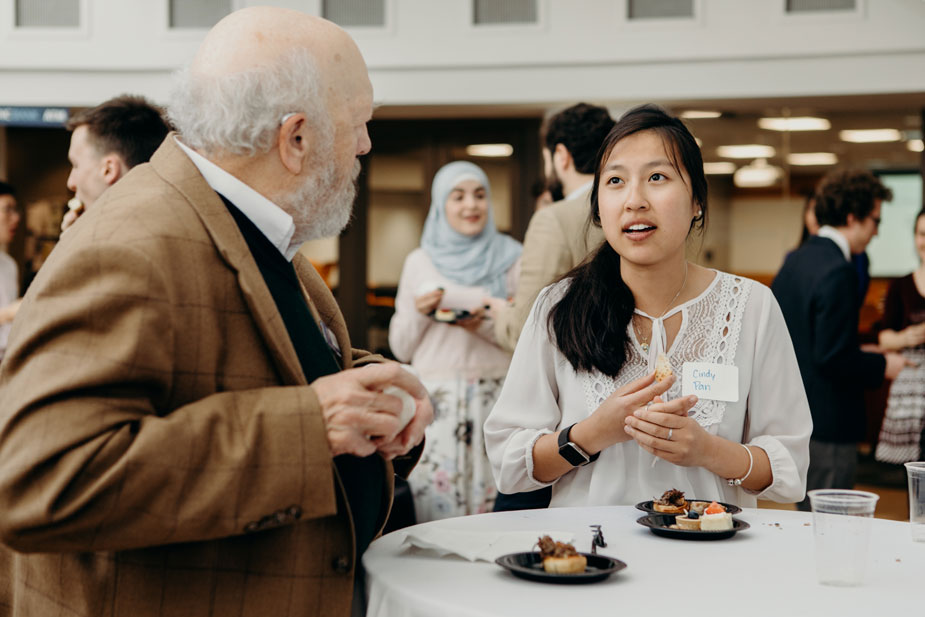 Photo of Tom Kicher talking with a student at an event