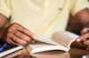 Photo of a man reading a book at a desk