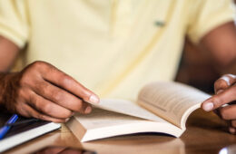 Photo of a man reading a book at a desk