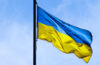 Photo of a Ukraine flag flying with blue sky in background