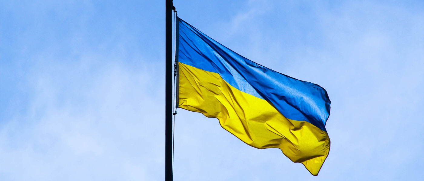 Photo of a Ukraine flag flying with blue sky in background