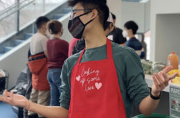 Photo of Case Western Reserve University student Winston Li wearing a cooking apron at a campus event