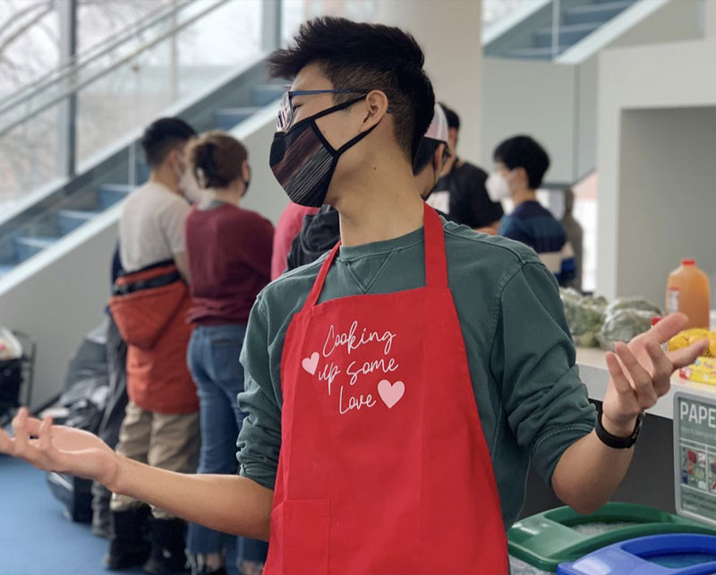 Photo of Case Western Reserve University student Winston Li wearing a cooking apron at a campus event