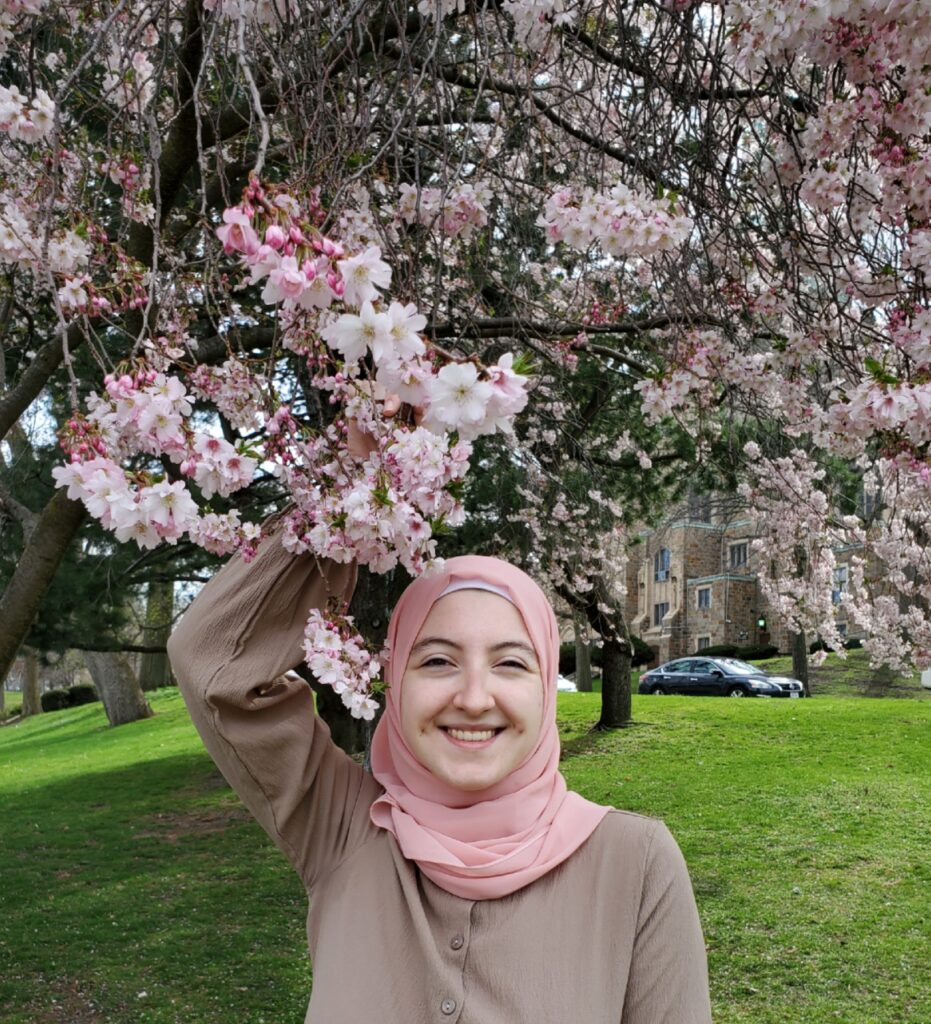 Photo of Nour Lababede under a cherry blossom tree