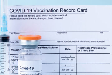 Blank vaccination card with syringe and covid-19 test vial