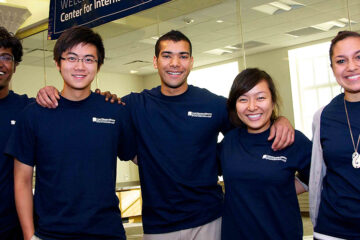 CWRU student volunteers pose in matching t-shirts at the Center for International Affairs' grand opening in 2011