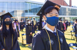 Photo of Case Western Reserve University 2021 commencement outdoors with focus on one student looking at camera