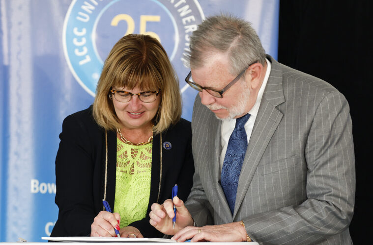 Photo of CWRU President Eric W. Kaler and Lorain County Community College President Marcia Ballinger sining a cooperative agreement.