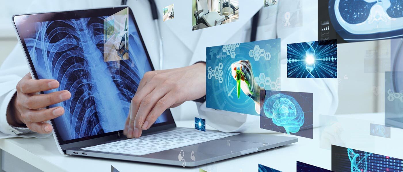 Hands holding a lap top and images depicting medical charts to signify artificial intelligence