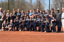 CWRU softball team, President Kaler and Lou Stark holding up fingers to signify #1